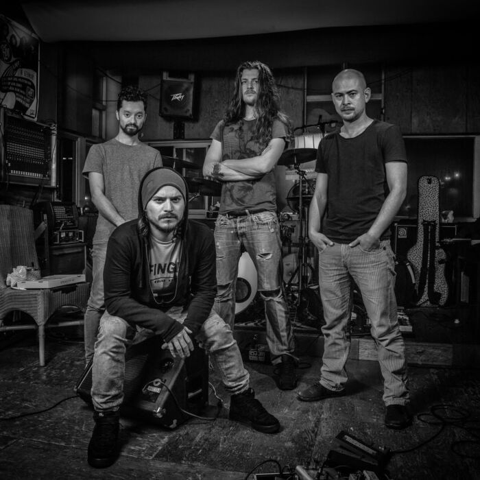 Zwart-witfoto van vier bandleden van Rage Against The Machine tributeband Guerilla Radio. Half staand, half zittend.