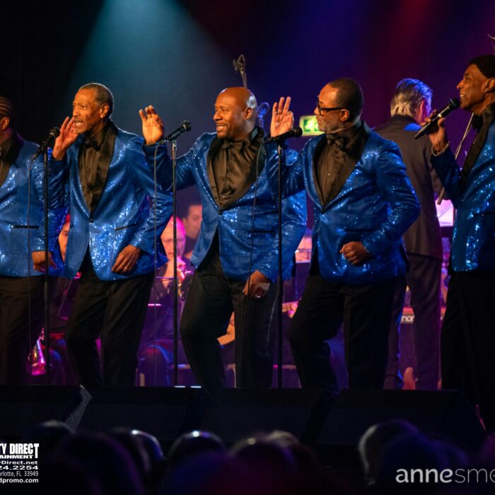 The Temptations ft. Glenn Leonard staan op het podium te performen.