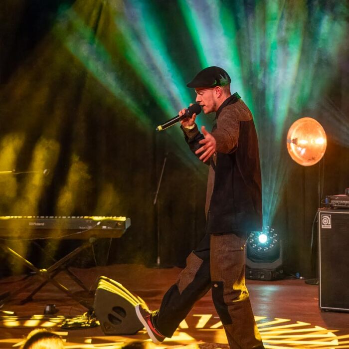 Rapper Equivocal performt in de kleine zaal van De Vorstin met microfoon in zijn hand