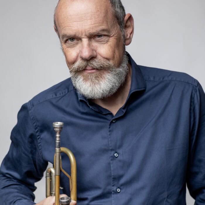 Trompettist en bugelist Angelo Verploegen houdt blaasinstrument vast in rechterhand.