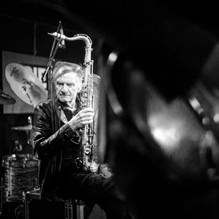 Zwart-witfoto van Hans Dulfer op het podium, naar beneden kijkend met saxofoon in de hand.