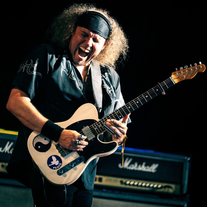Bluesgitarist Julan Sas performt expressief op het podium met gitaar in de hand, mond wijd open en ogen dicht.
