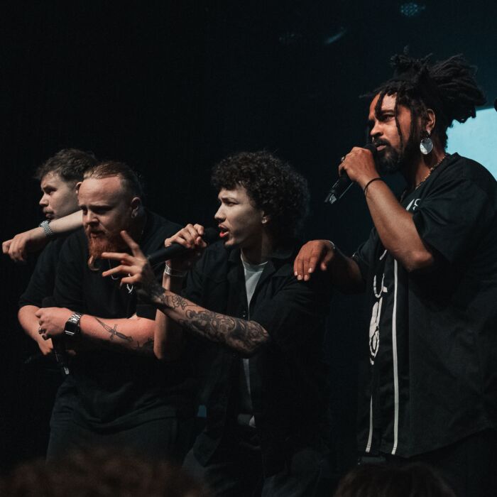 RaVijf rappers van collecties Gooise Woordenaars staan op een rijtje te performen op het podium.