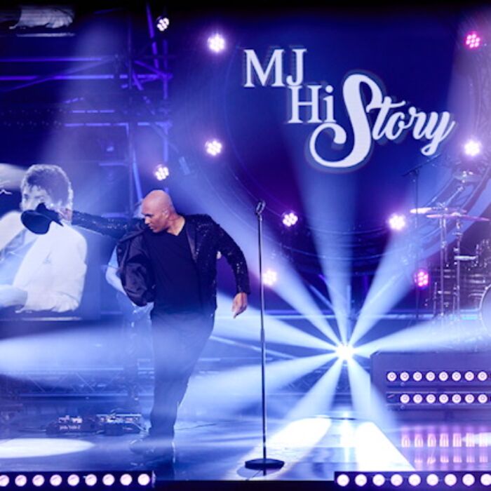 Performance van Michael Jackson tributeact MJ HIStory. Danser en drummer staan te performen met blauwe lichten op de achtergrond.