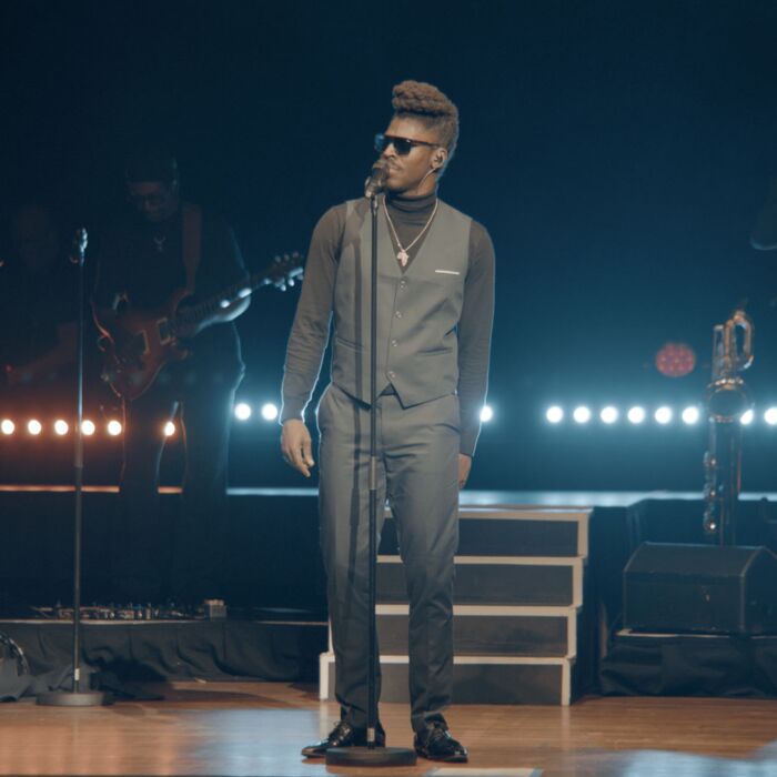 James Brown tribute-zanger staat op het podium met zwarte zonnebril op.