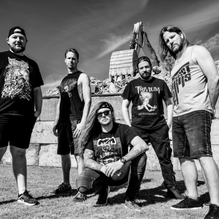 Zwart-witfoto van bandleden metalband Loyalty Ends Here. Ze poseren zittend en staand voor de camera.