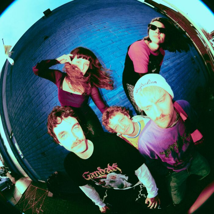 Kleurrijke foto van bandleden Honey I'm Home, met fish-eye camera effect.